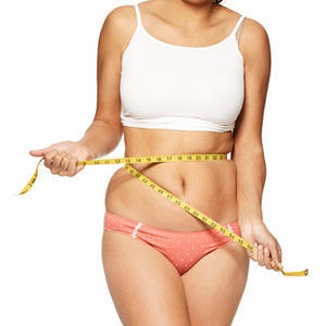 Menina com sobrepeso medindo a cintura